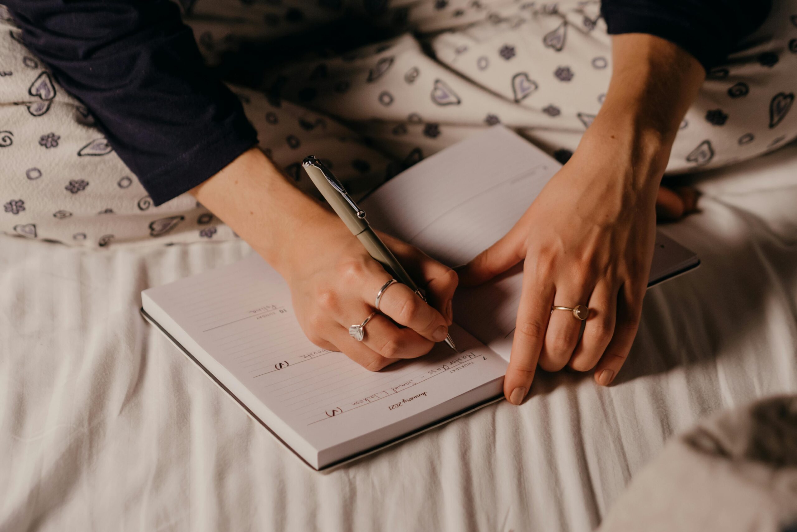 Woman journaling in bed.