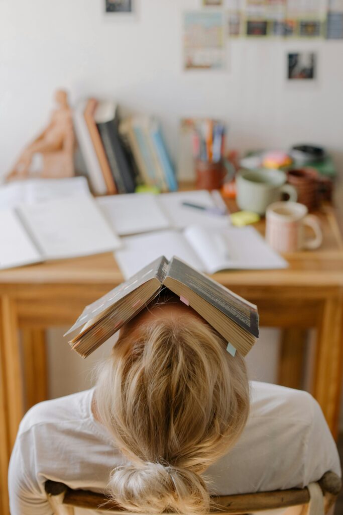girl with disorganized desk, distracted, discouraged, and delaying work