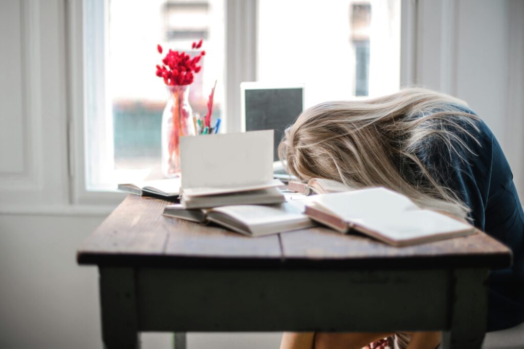girl with disorganized desk, distracted, discouraged, and delaying work